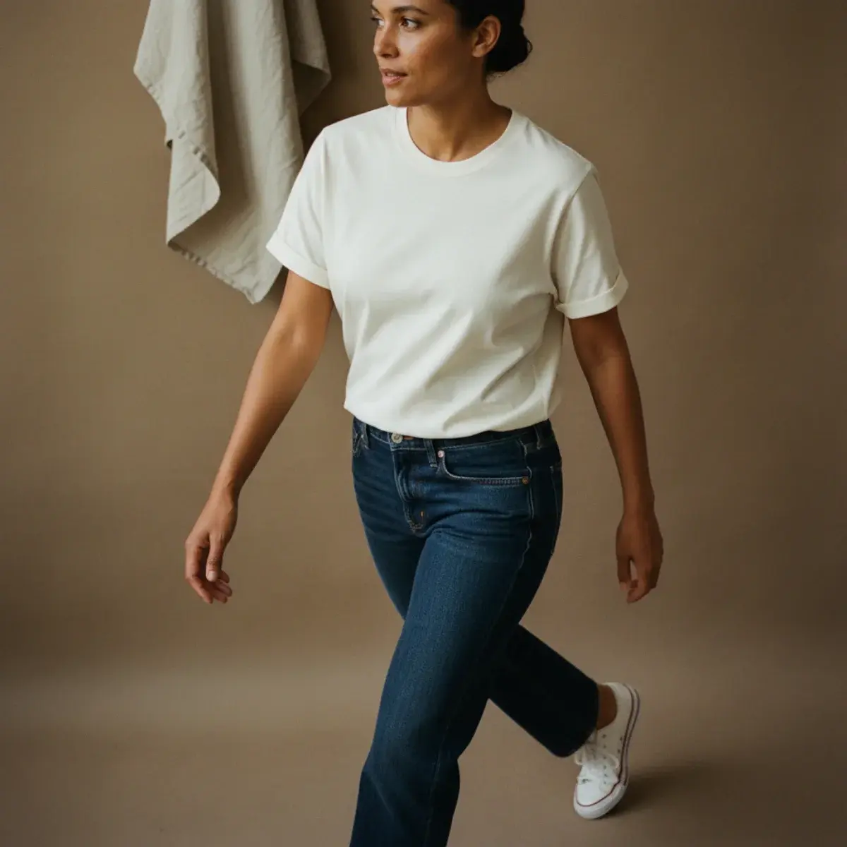 Woman in a well-fitting tee, straight jeans, and clean white trainers looking put-together and relaxed