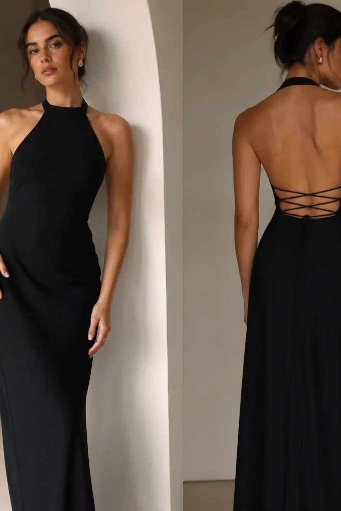 A black crepe halter dress with a halter neckline, clean front, and a corset-like back lacing; long straight skirt.