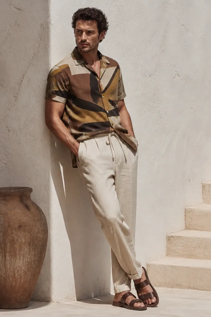 Patterned short-sleeve shirt with light linen trousers and tan leather sandals
